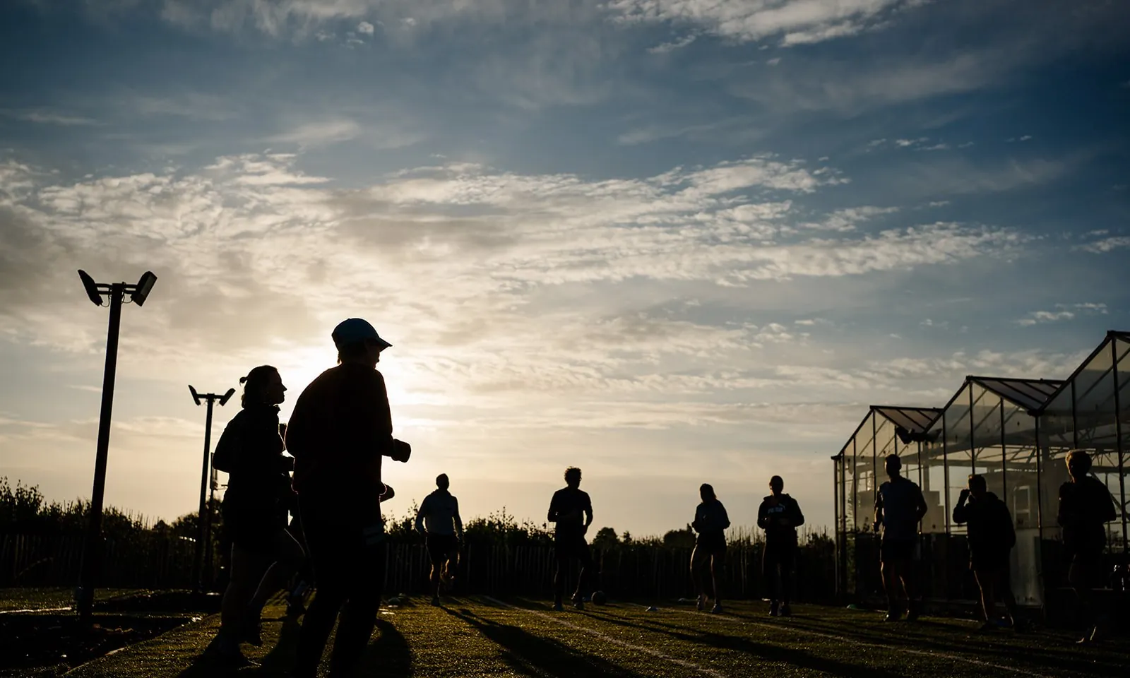 Groep traint bij zonsondergang op het veld naast de club