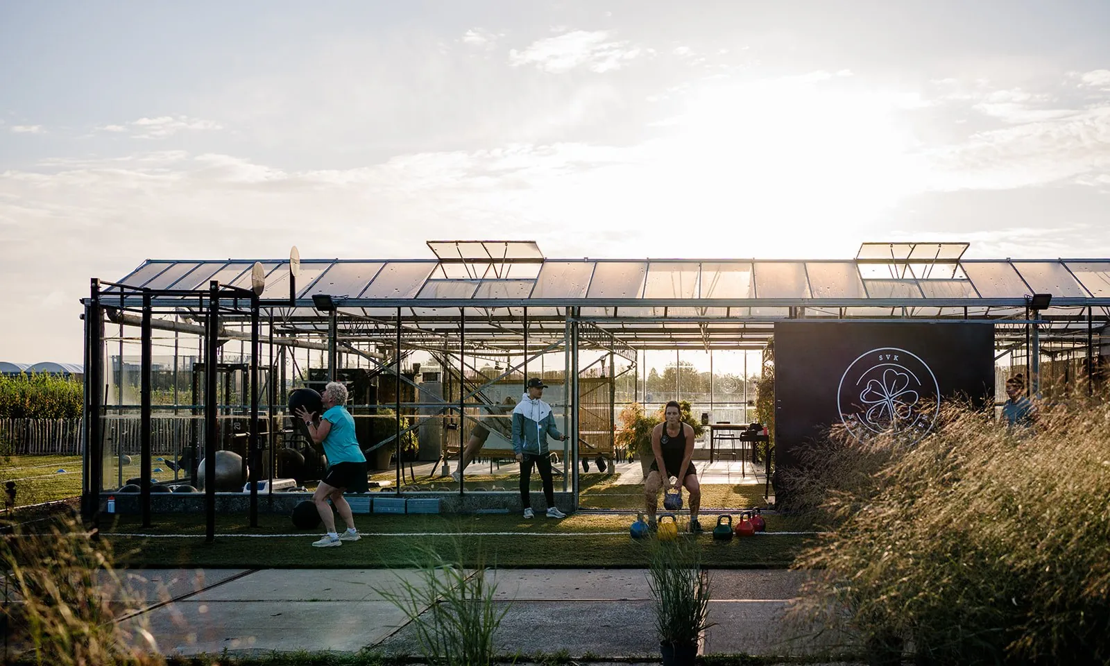 De club bij zonsondergang met sporters op het buitenveld