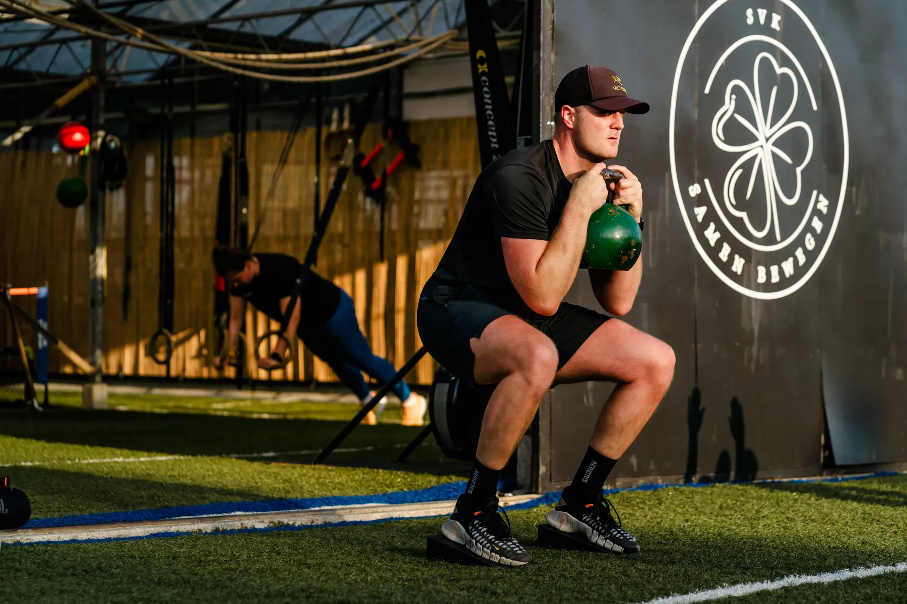 Kettlebell-squat voor de logowand