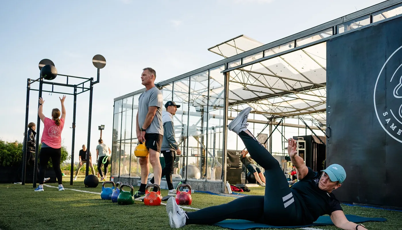 Groepsles buiten op het veld bij de club, met kettlebells en oefeningen op de mat